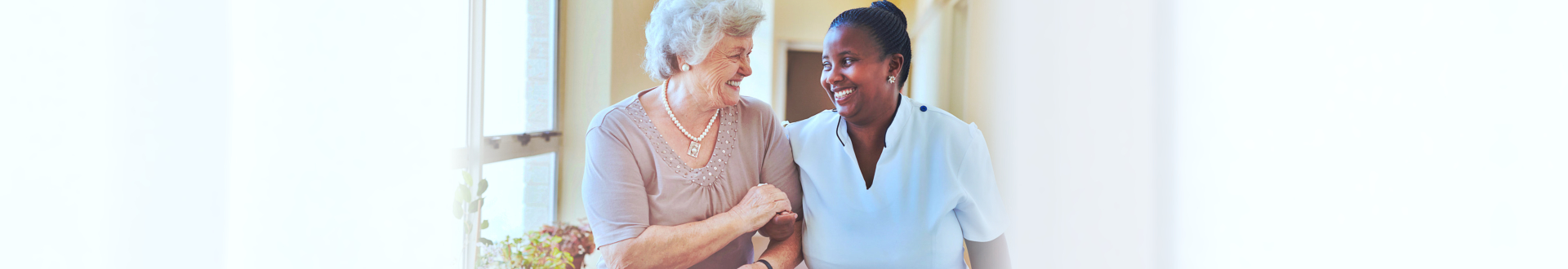 senior woman smiling together with caregiver